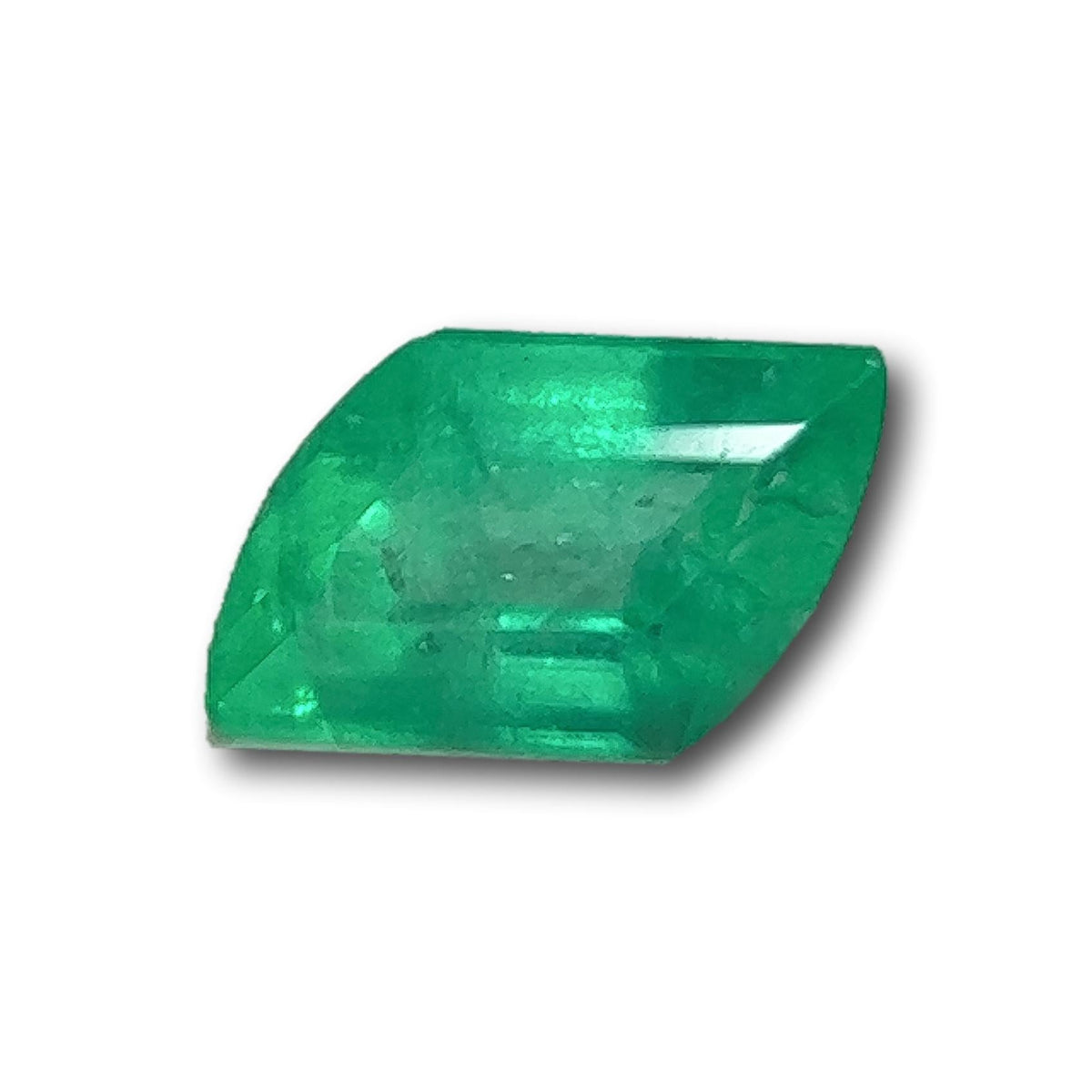 0.58ct Muzo emerald with a unique rhomboid step cut and vibrant green color, isolated on a white background.