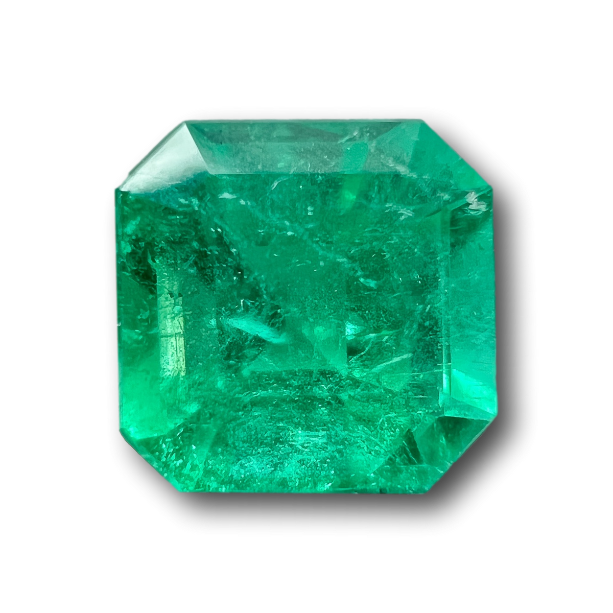 Radiant cut Muzo Colombian emerald, 0.67ct, featuring a vibrant green hue and faceted gemstone texture.