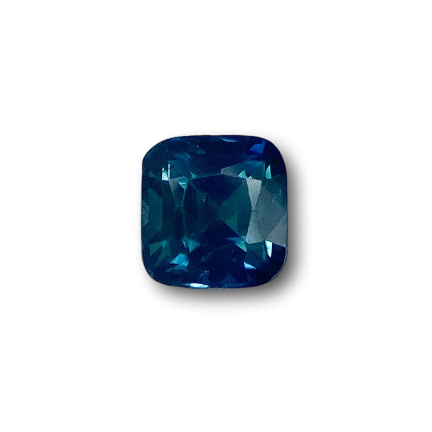 0.91ct cushion-cut blue Montana sapphire with a brilliant facet pattern on a white background.