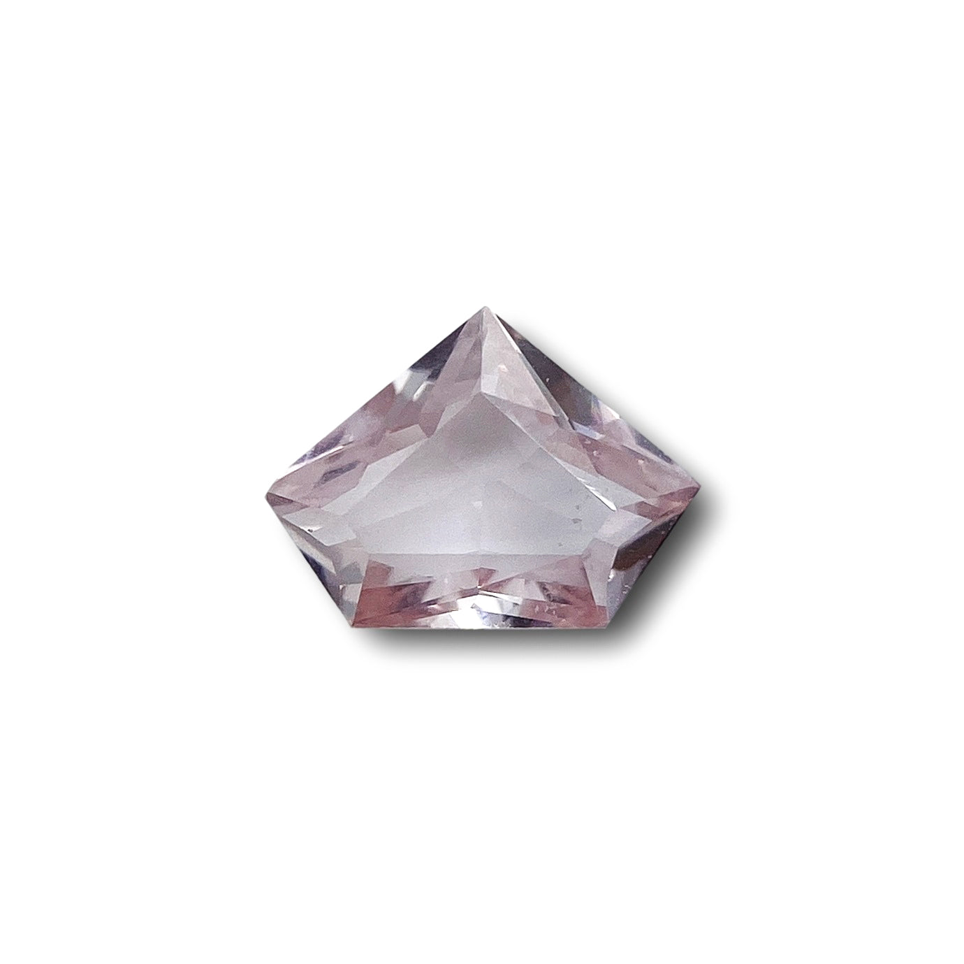 0.91ct brilliant cut pink sapphire in a unique shield shape against a white background.