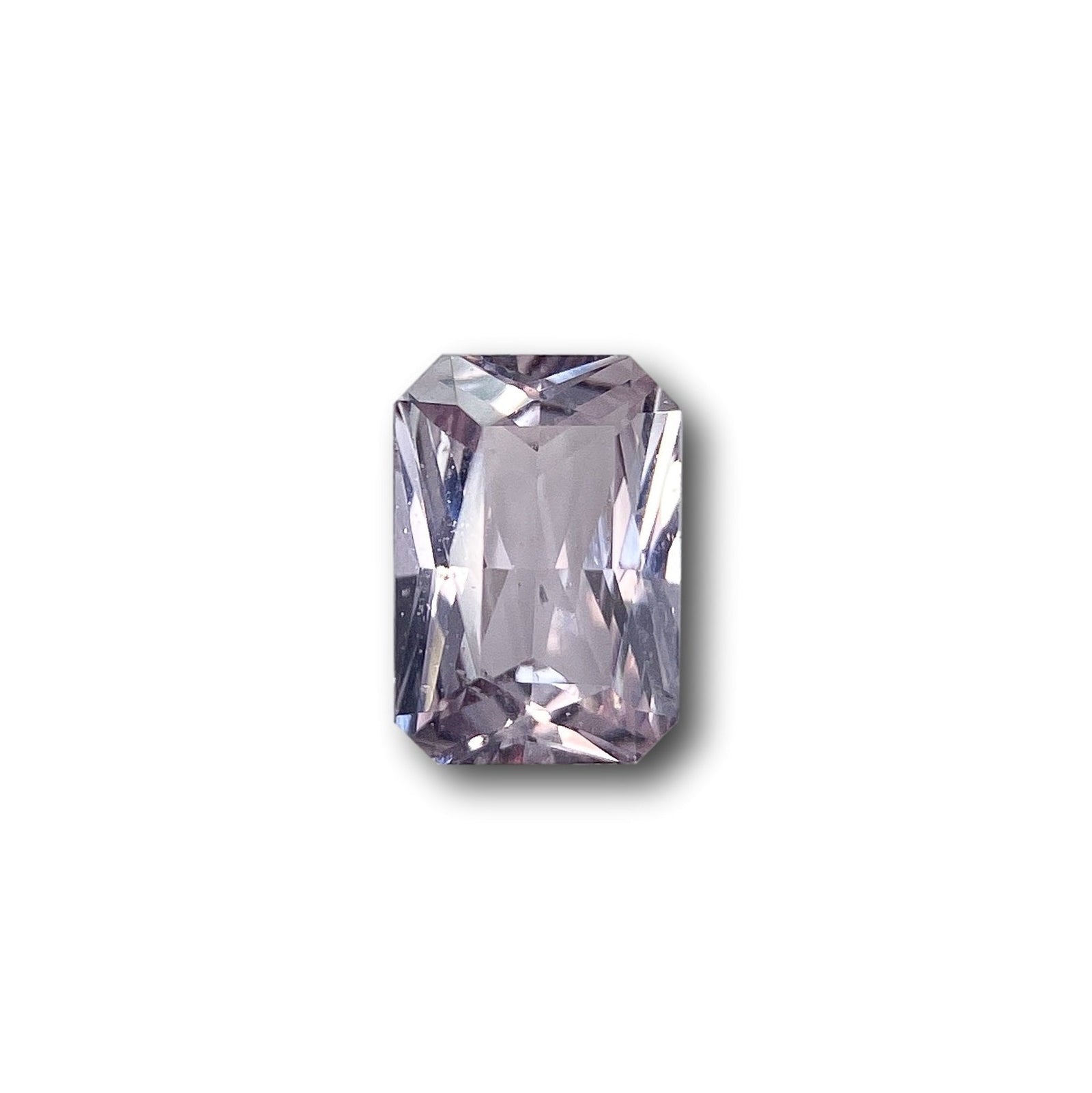 0.92ct radiant cut pink sapphire gemstone with a faceted rectangular design isolated on a white background.