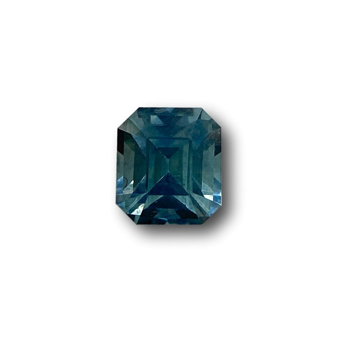 0.94ct Asscher cut blue Montana sapphire with a square step-cut design and deep blue tones on a white background.