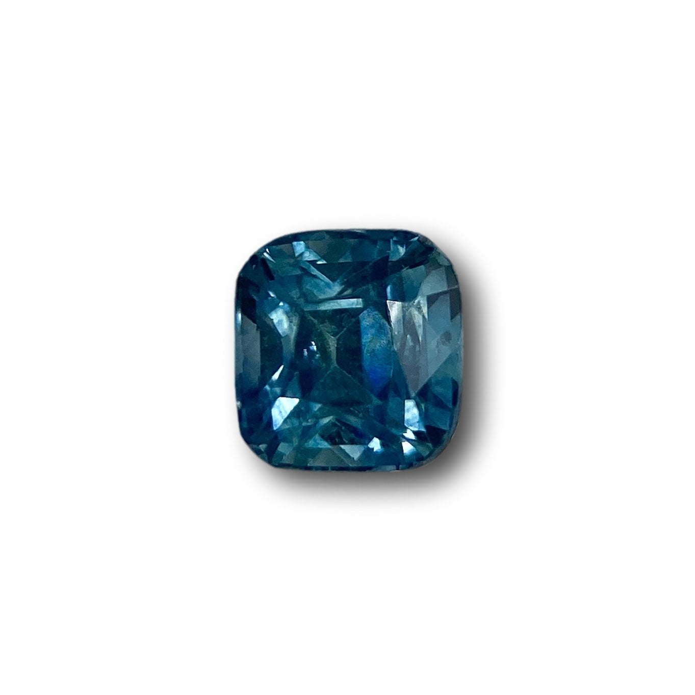 0.98ct cushion-cut blue Montana sapphire with a brilliant faceted finish isolated on a white background.