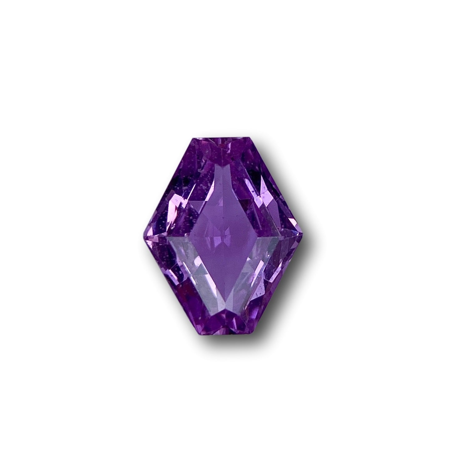 1.00ct brilliant cut violet sapphire in a unique lozenge shape, measuring 7.60 x 6.10 mm against a white background.