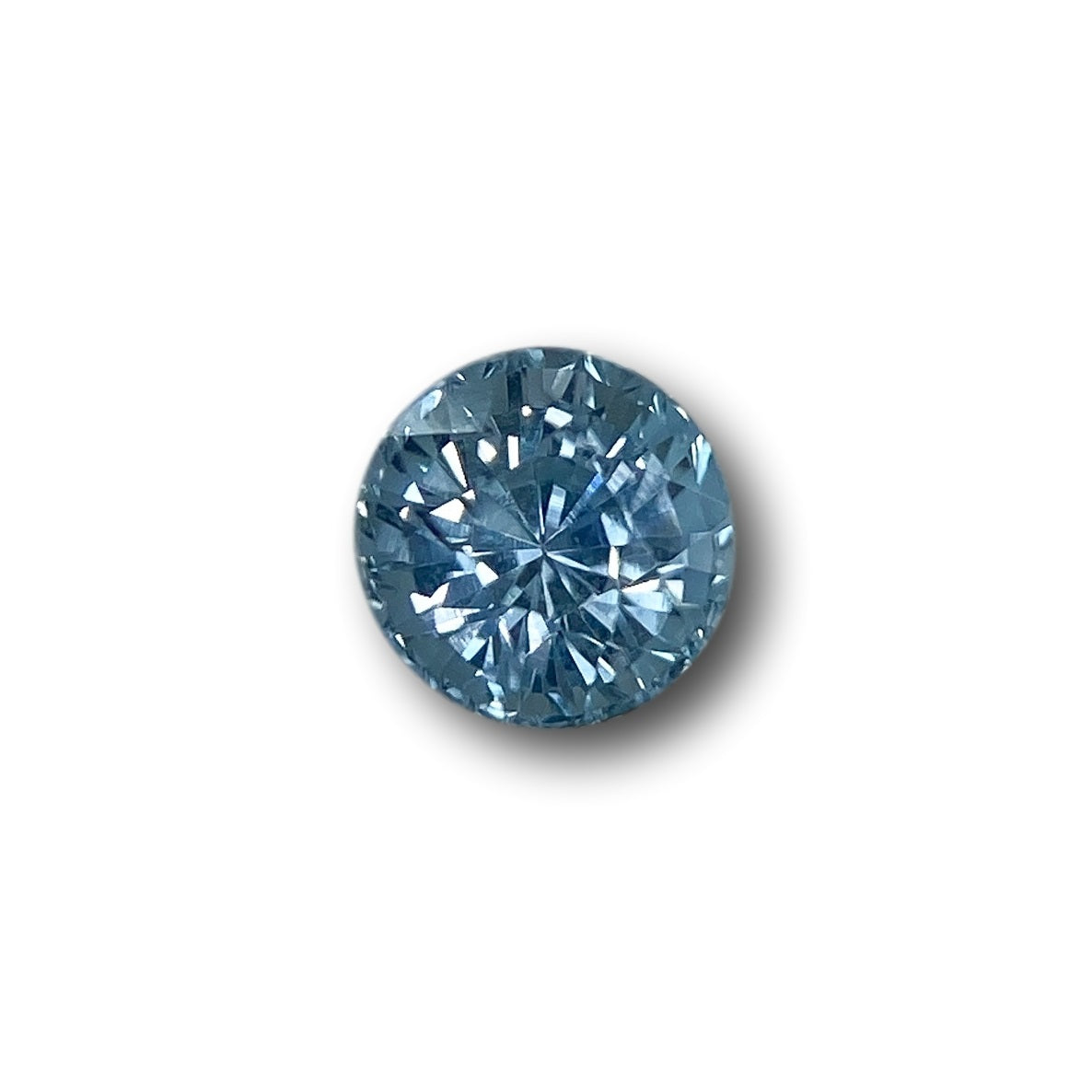 1.02ct round brilliant cut blue Montana sapphire with faceted sparkle on a white background.