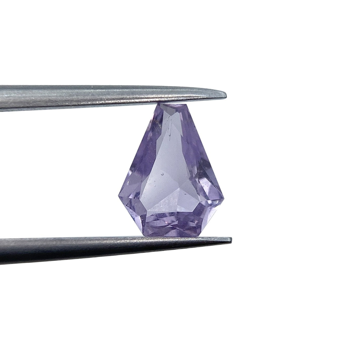 1.03ct brilliant cut shield-shaped pink sapphire held in metal tweezers against a white background.