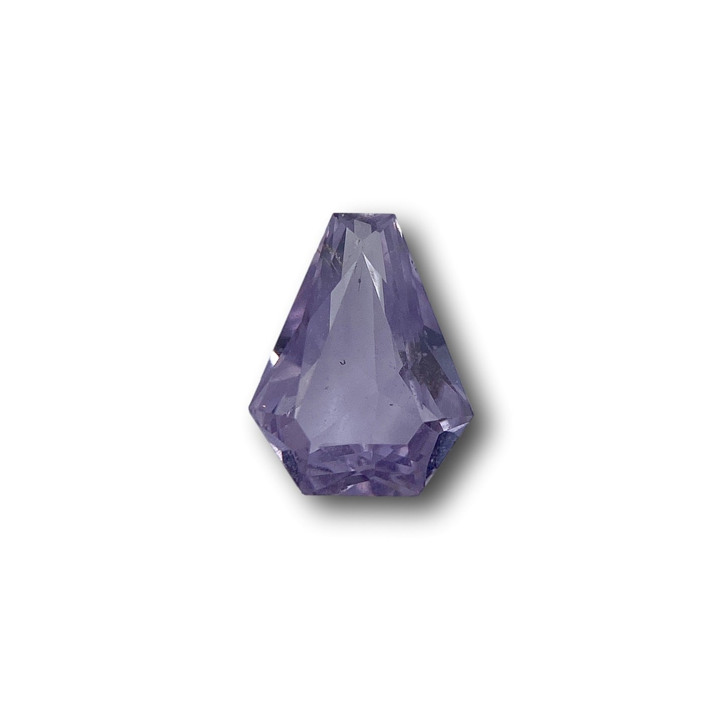1.03ct brilliant cut shield-shaped pink sapphire gemstone with faceted edges on a white background.
