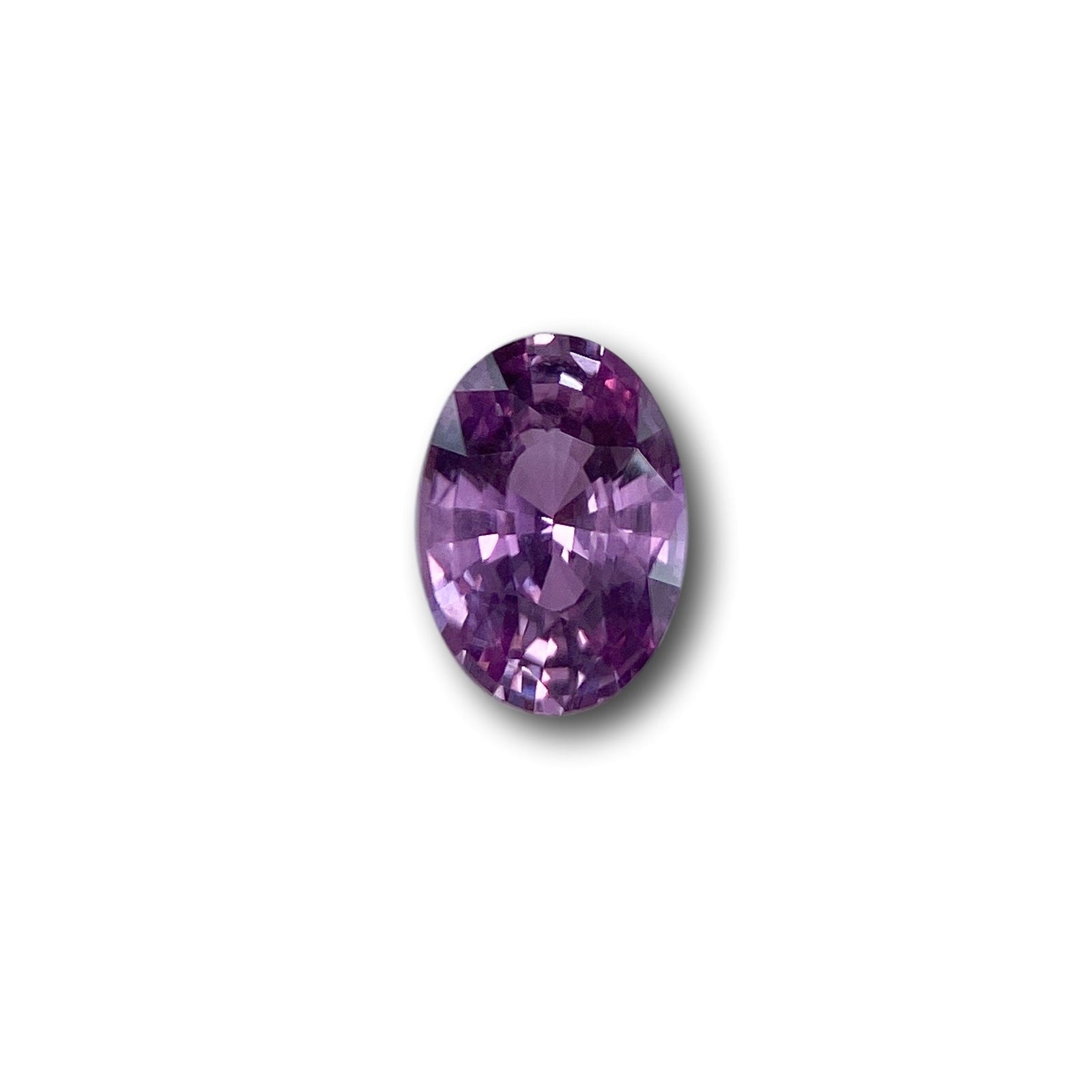 1.04ct oval brilliant cut violet sapphire gemstone with faceted surface on a white background.