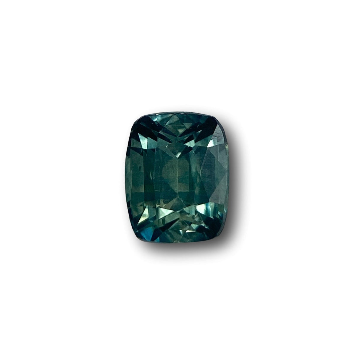 1.05ct cushion-cut green Montana sapphire with a brilliant faceted finish isolated on a white background.
