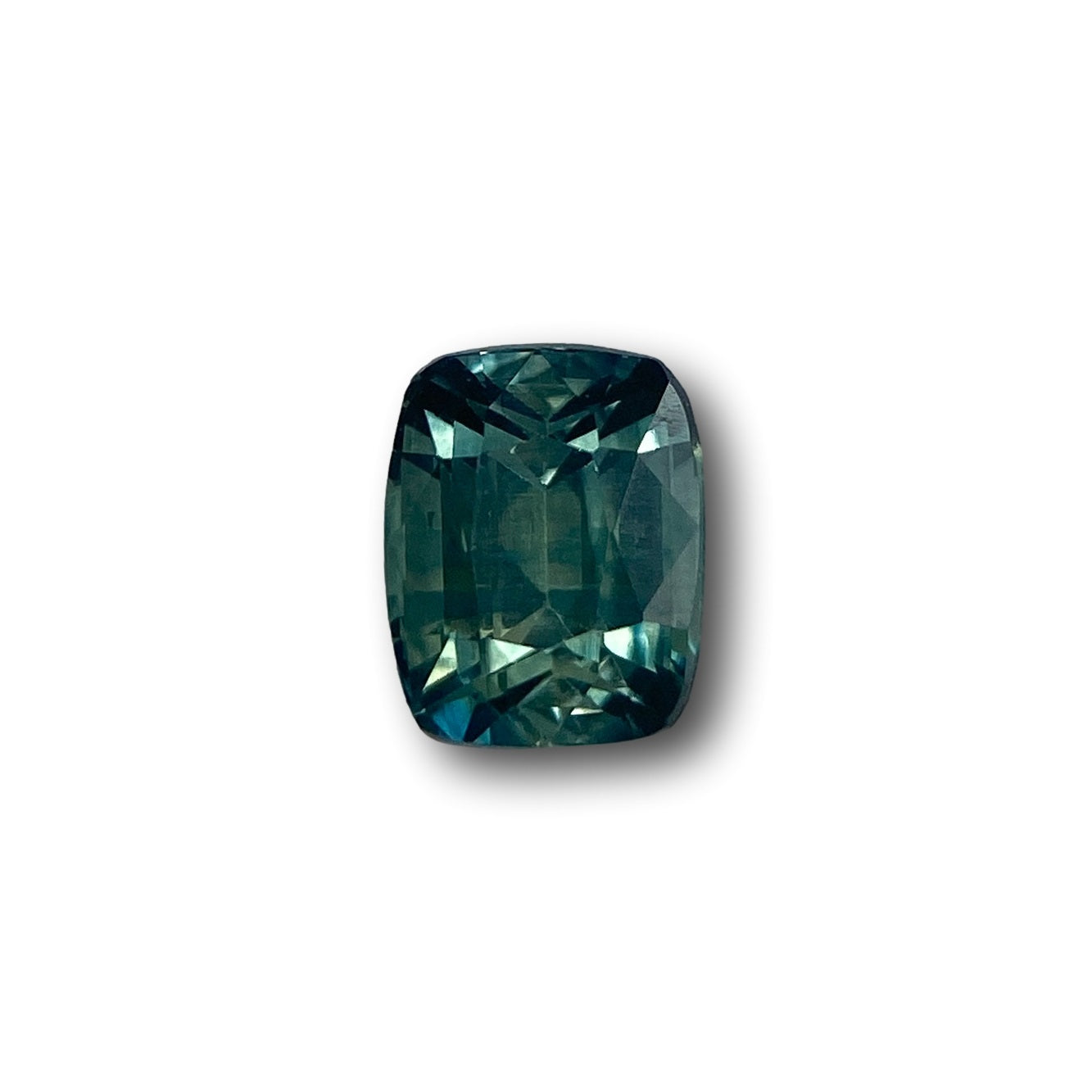 1.05ct cushion-cut green Montana sapphire with a brilliant faceted finish isolated on a white background.