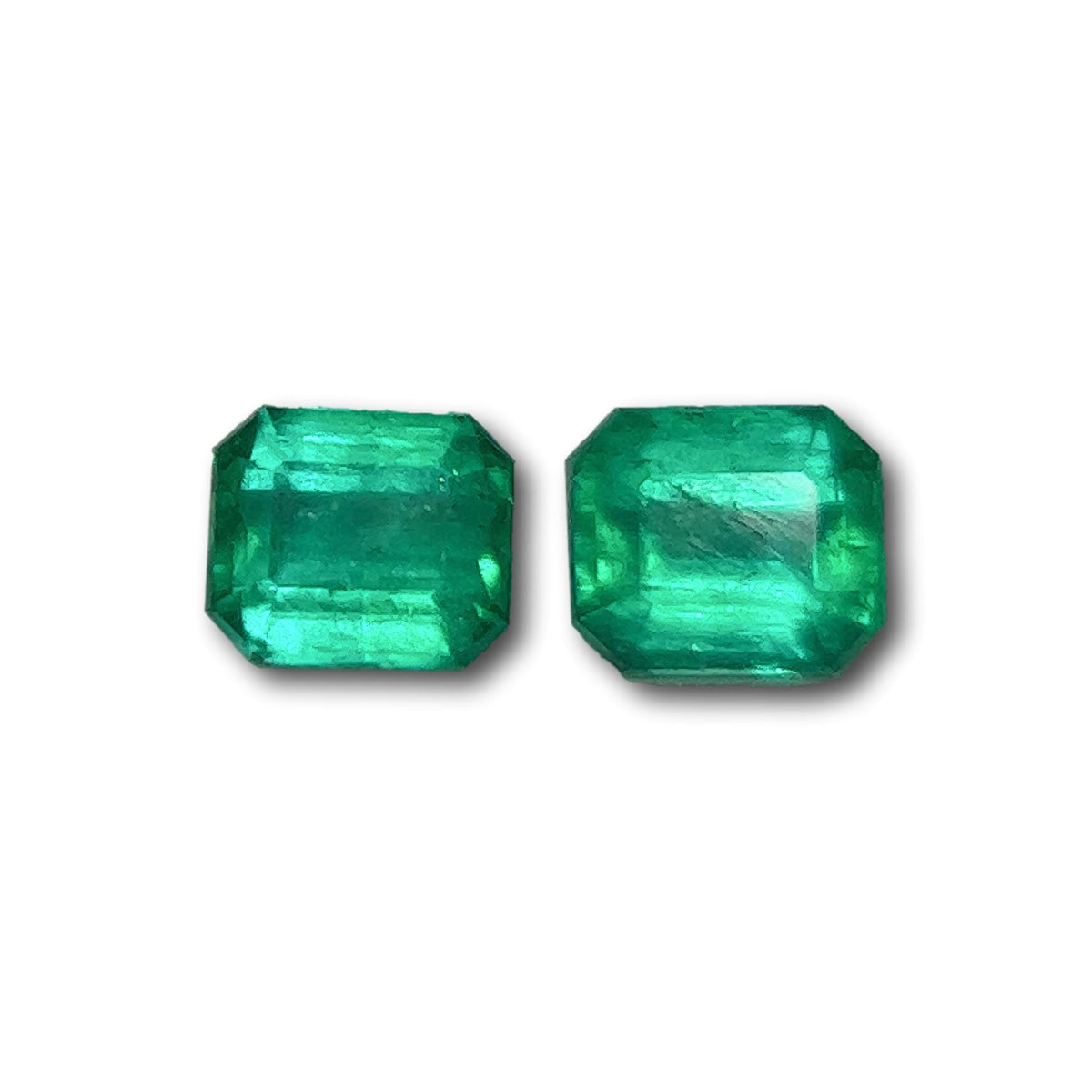Pair of 1.05ct Muzo emeralds with a vibrant green hue and elegant emerald step-cut design.