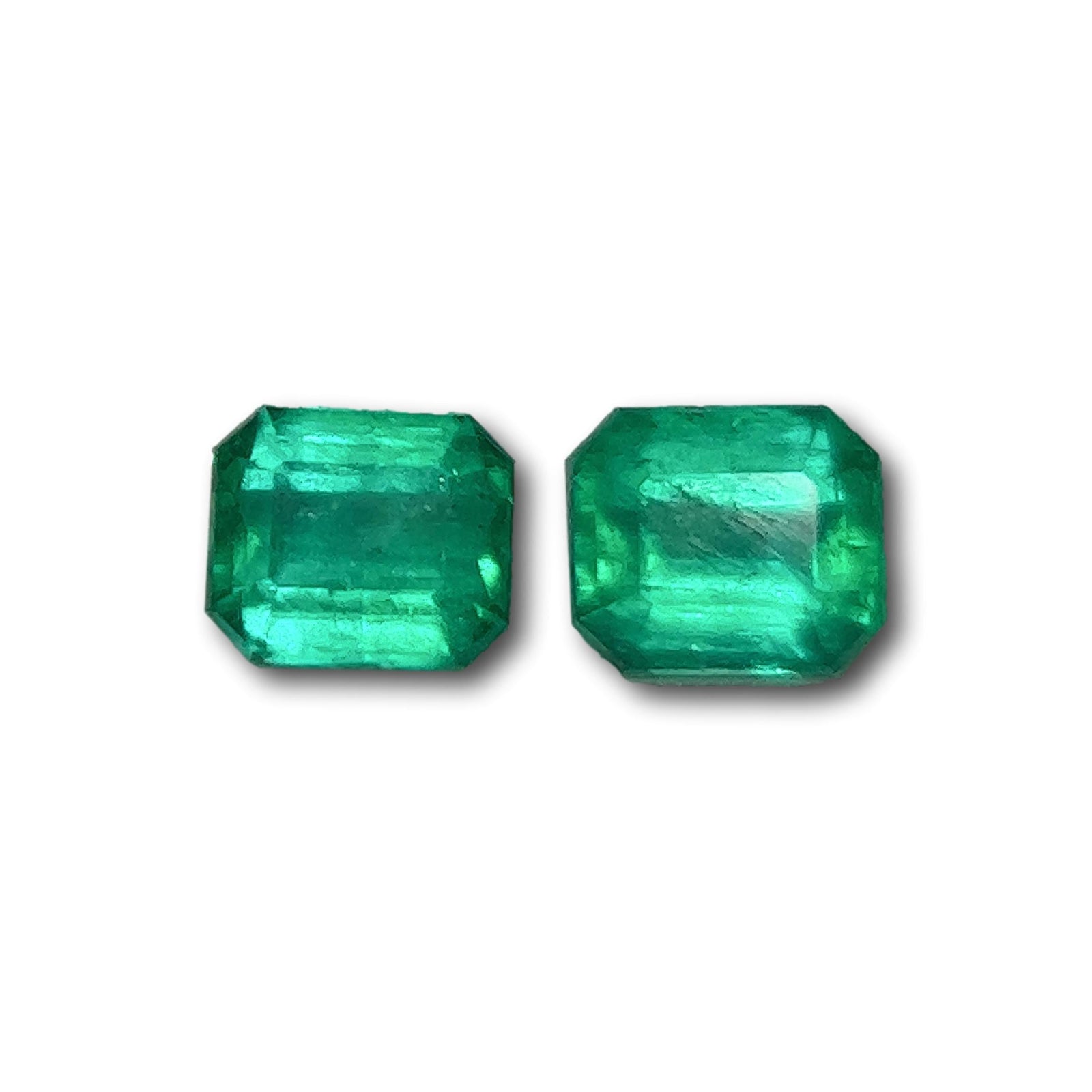 Pair of 1.05ct Muzo emeralds with a vibrant green hue and elegant emerald step-cut design.
