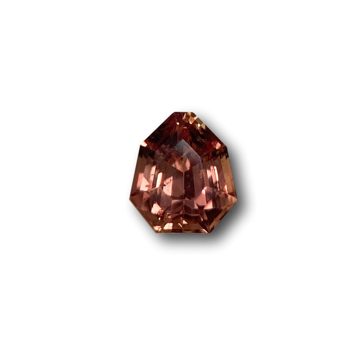 1.06ct brilliant cut brown sapphire with a unique shield shape and faceted surface on a white background.