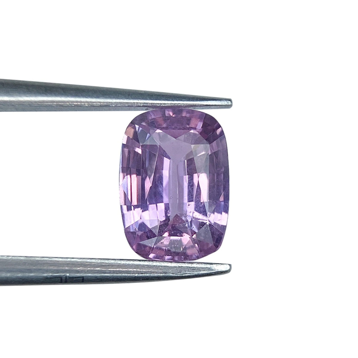 1.08ct cushion-cut violet sapphire gemstone held in metal tweezers against a white background.