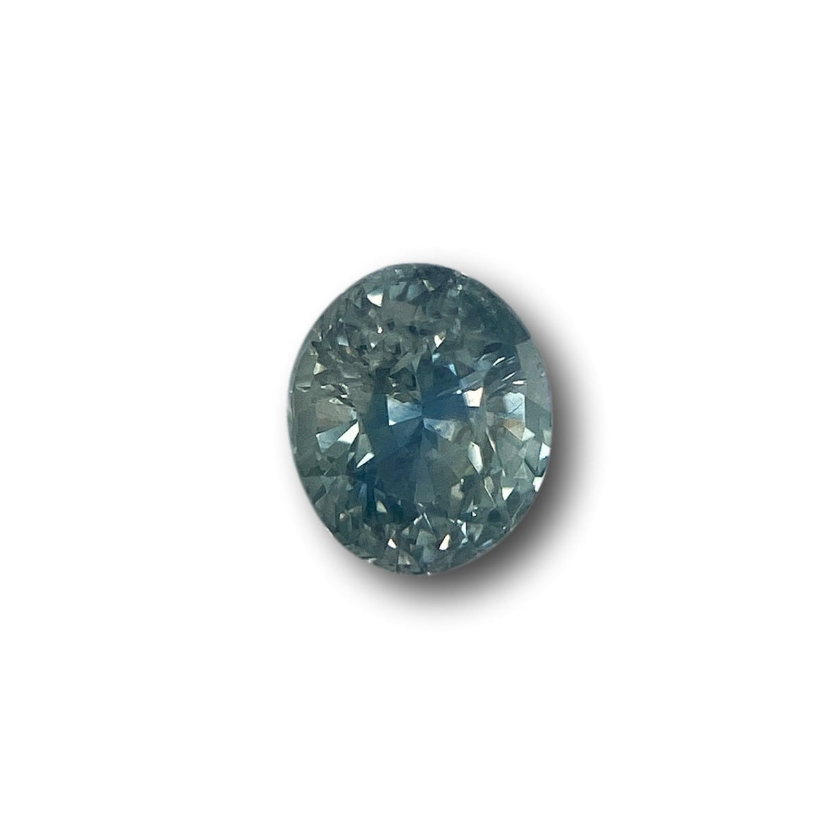 1.15ct oval brilliant cut blue Montana sapphire gemstone with faceted surface on a white background.