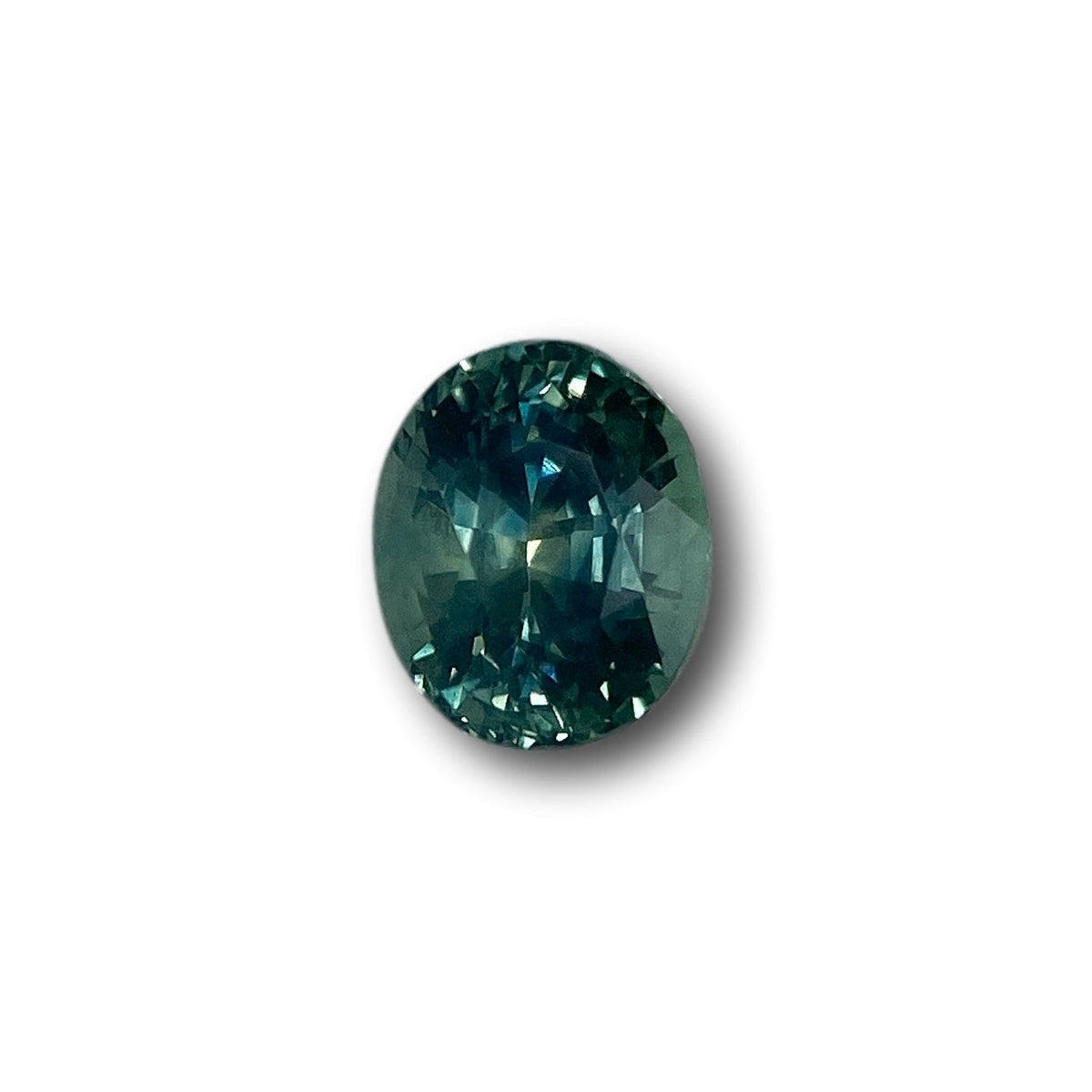 1.15ct oval brilliant cut green Montana sapphire gemstone with deep teal facets.