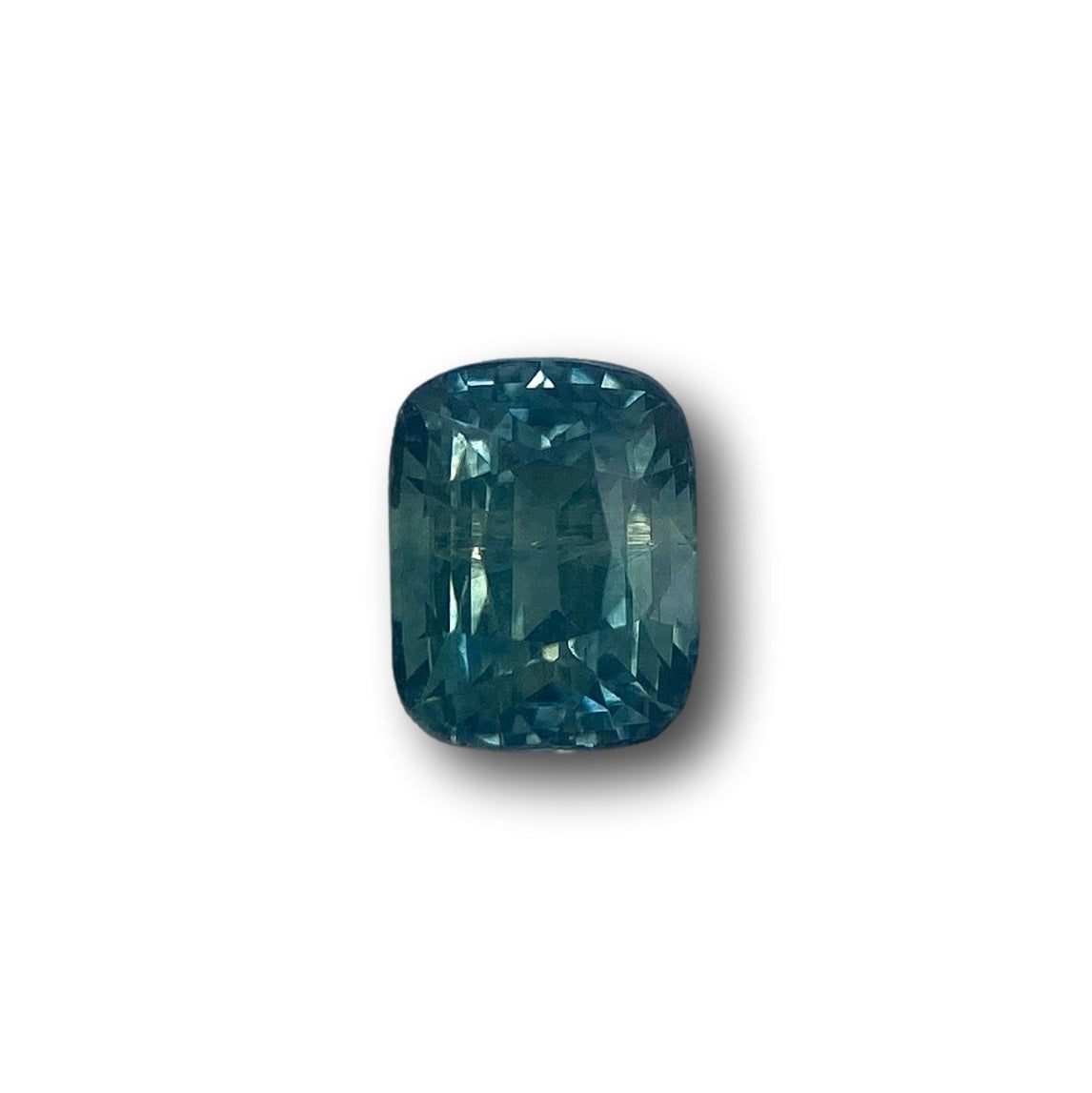 1.16ct brilliant cut cushion-shaped blue Montana sapphire gemstone with a faceted surface on a white background.