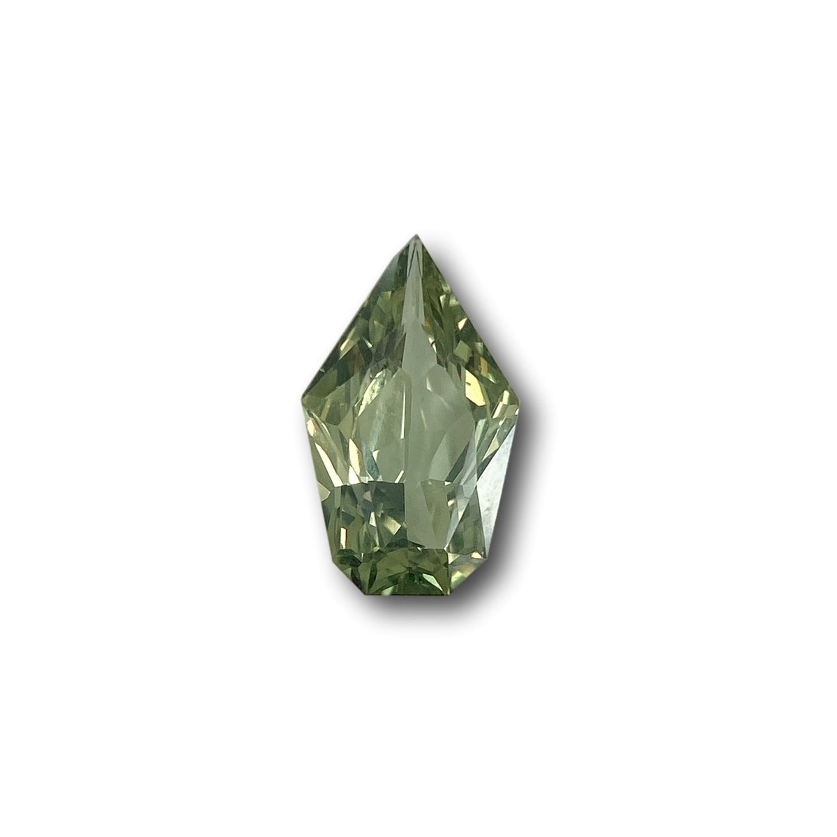 1.17ct brilliant cut shield-shaped green sapphire gemstone with faceted edges on a white background.