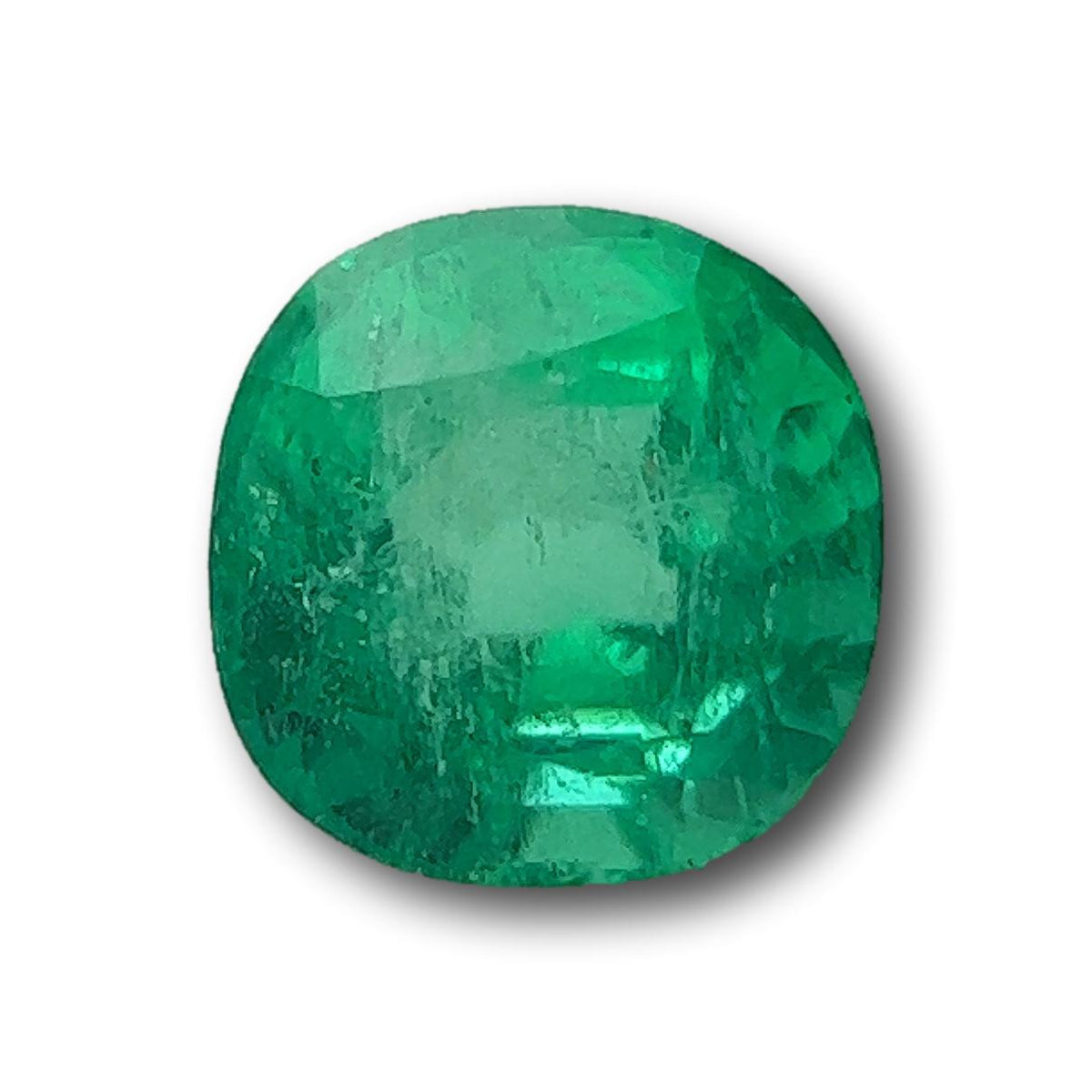 1.29ct brilliant cut cushion-shaped Muzo emerald with a vibrant green hue and faceted surface.