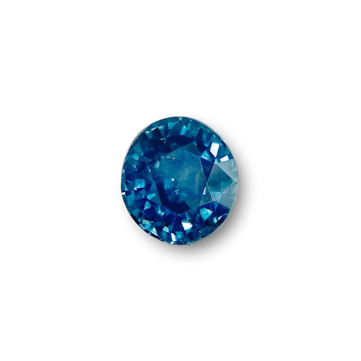 1.40ct brilliant cut oval blue Montana sapphire gemstone with deep blue facets isolated on a white background.
