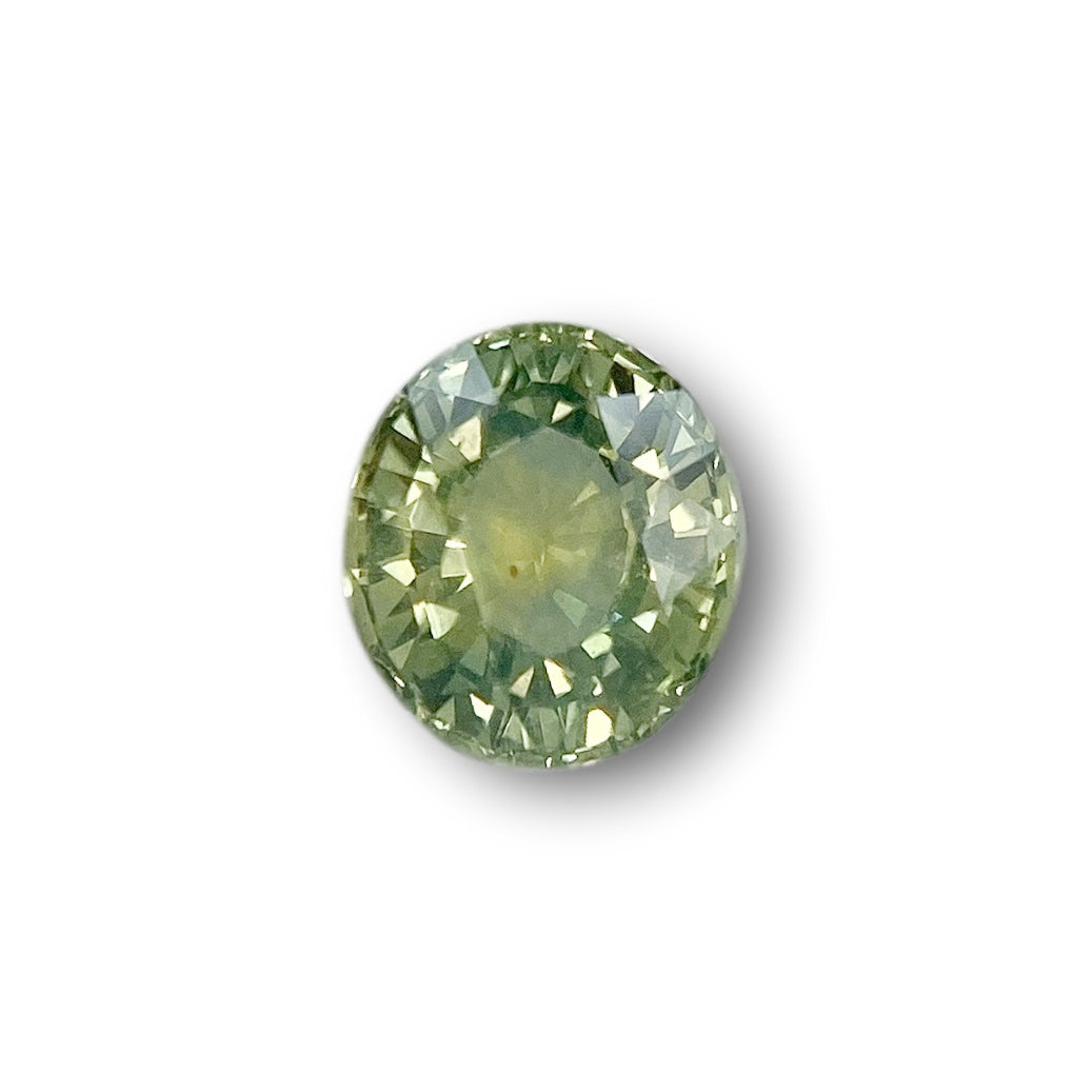 1.41ct oval brilliant cut green Montana sapphire gemstone with faceted surface.