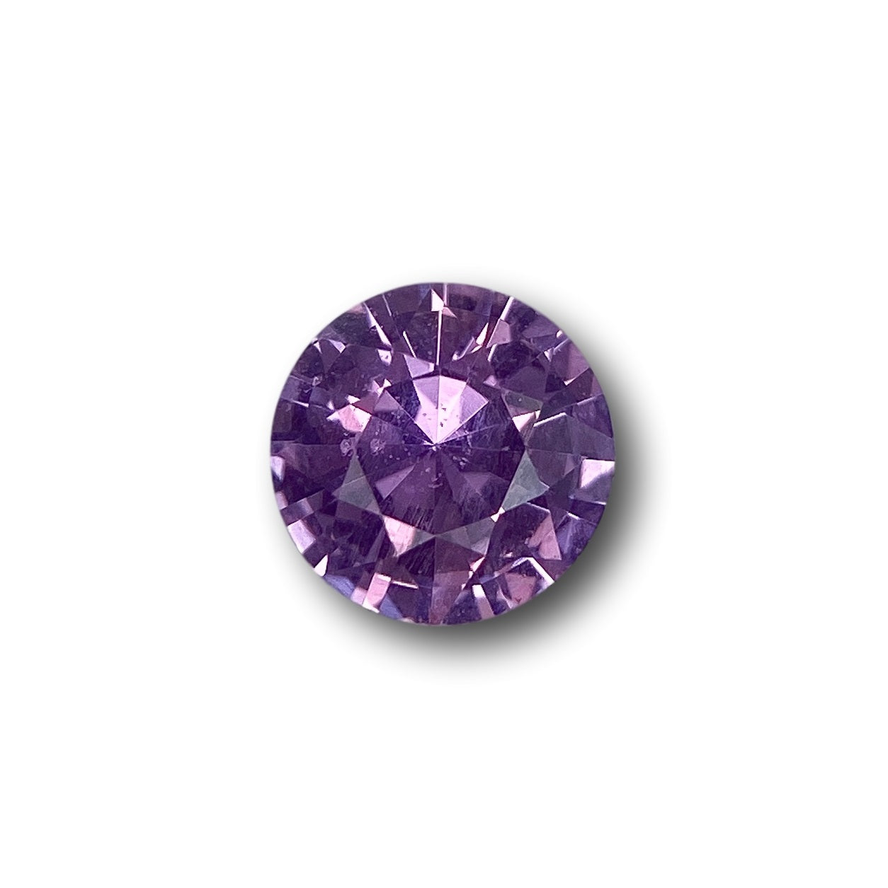 1.44ct round brilliant cut violet sapphire gemstone with faceted surface on a white background.