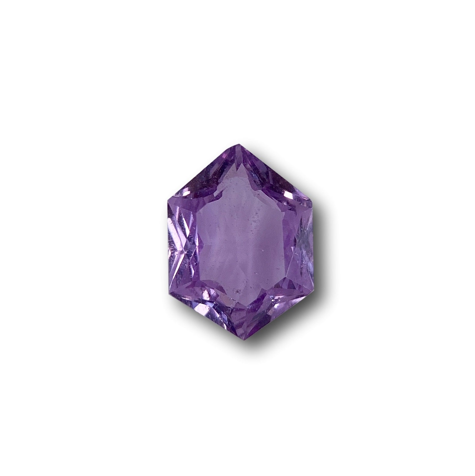 1.45ct brilliant cut violet sapphire in a unique hexagon shape against a white background.