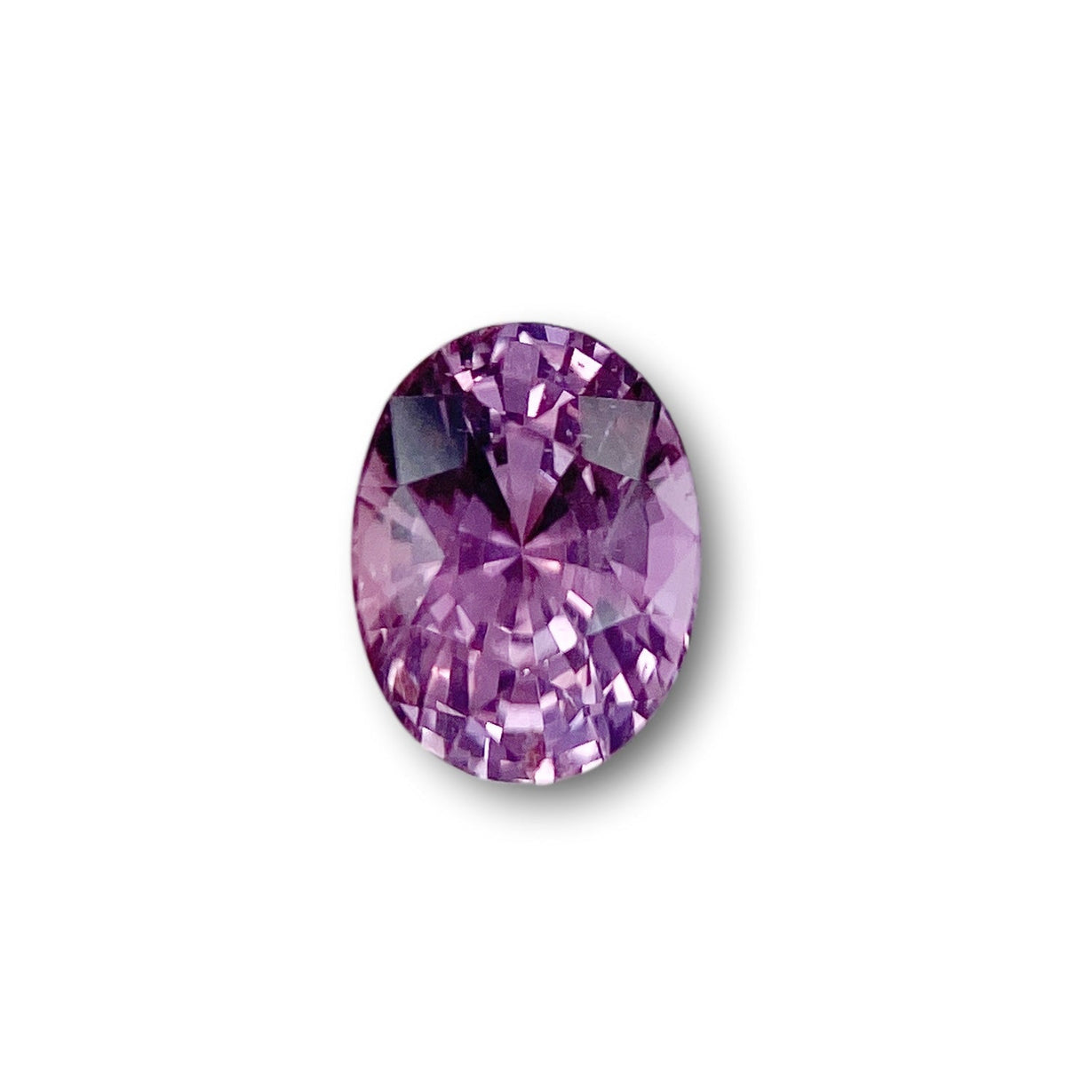 1.59ct oval-cut violet sapphire with a brilliant faceted finish isolated on a white background.