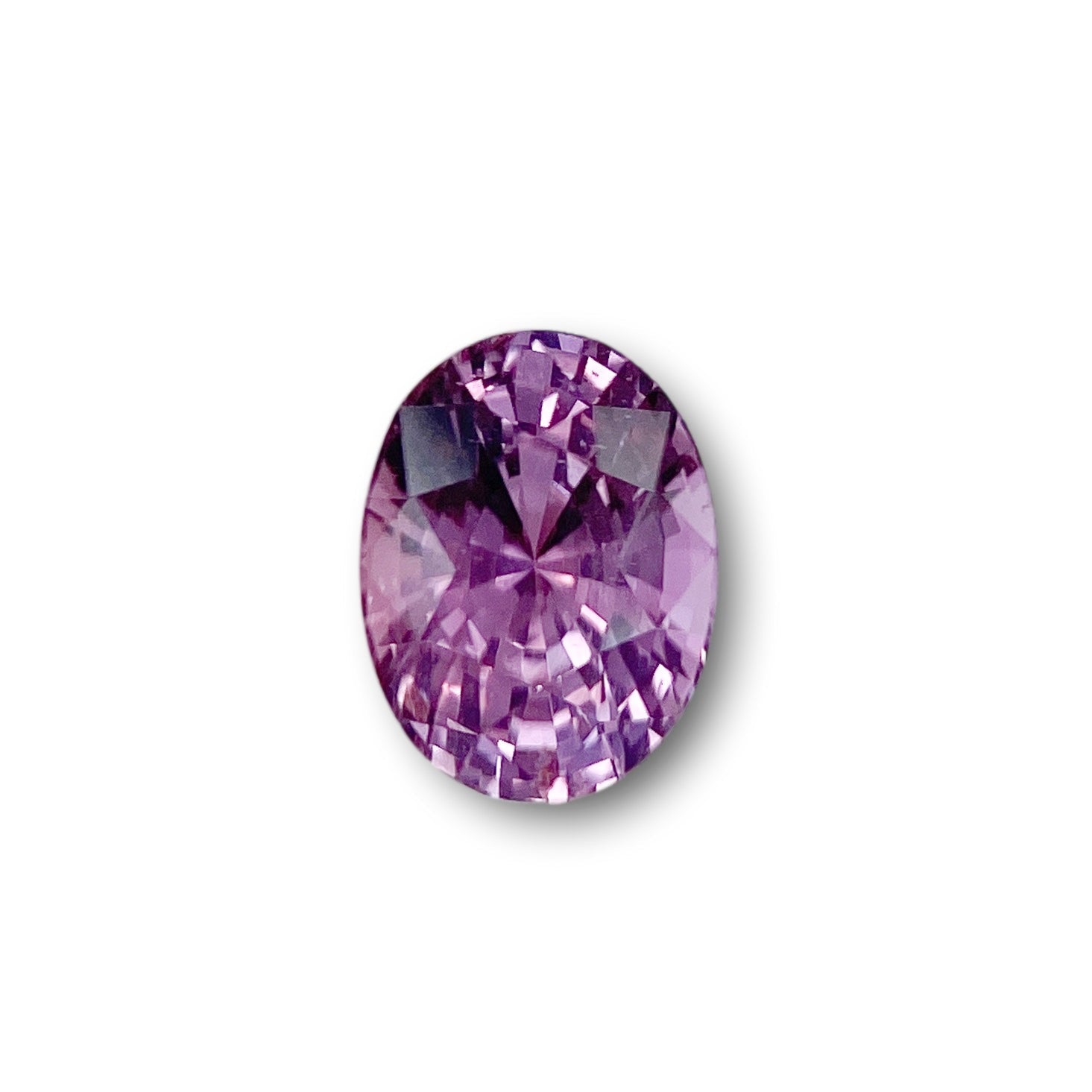 1.59ct oval-cut violet sapphire with a brilliant faceted finish isolated on a white background.