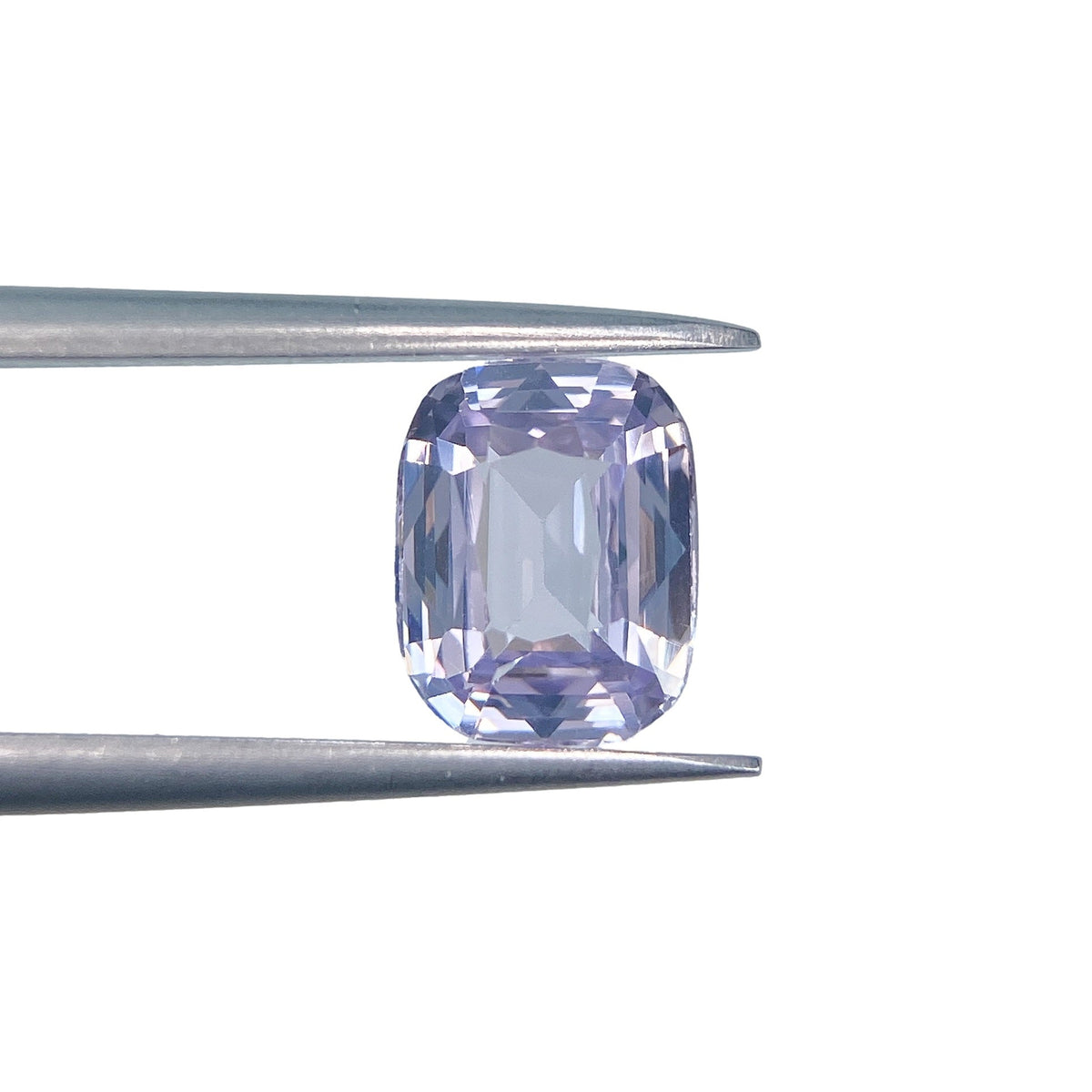 1.71ct cushion-cut blue spinel gemstone held in metal tweezers against a white background.