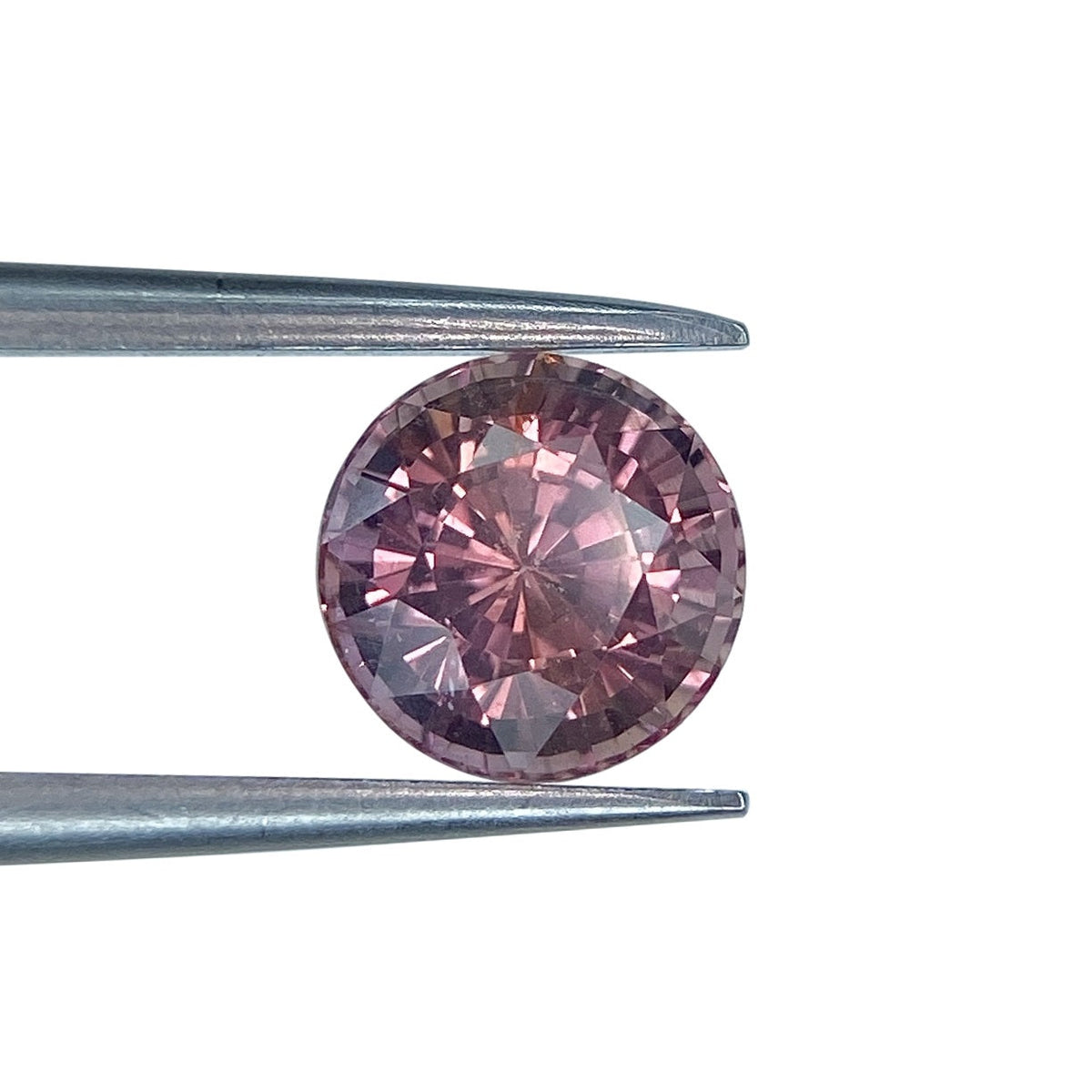 1.72ct round brilliant cut pink sapphire held in metal tweezers against a white background.