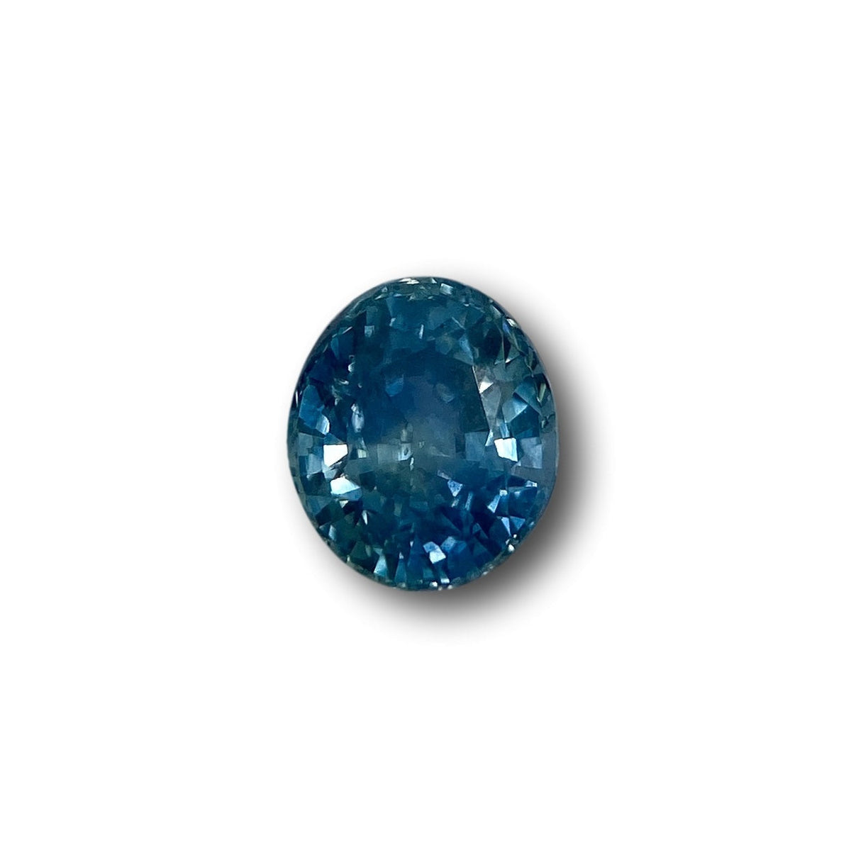 1.96ct oval brilliant cut blue Montana sapphire gemstone with faceted surface on a white background.