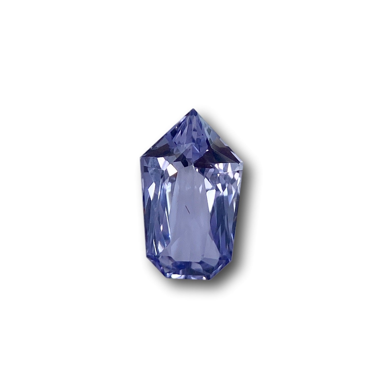 1.96ct brilliant cut blue sapphire in a unique shield shape with faceted edges on a white background.