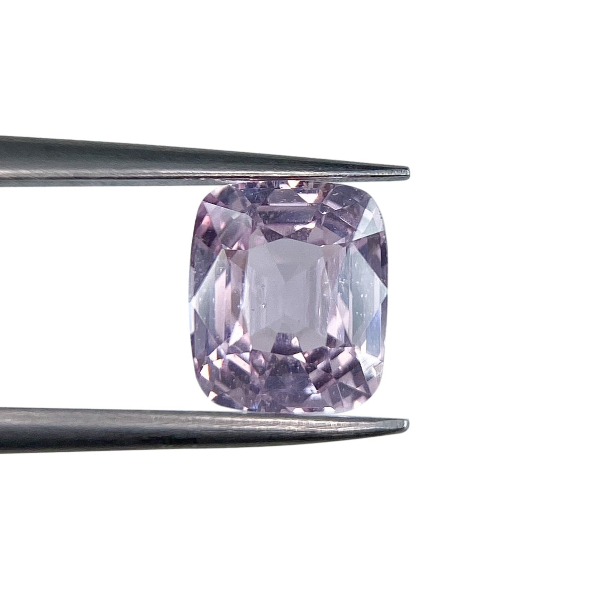 2.04ct brilliant cut cushion-shaped pink sapphire held in metal tweezers against a white background.