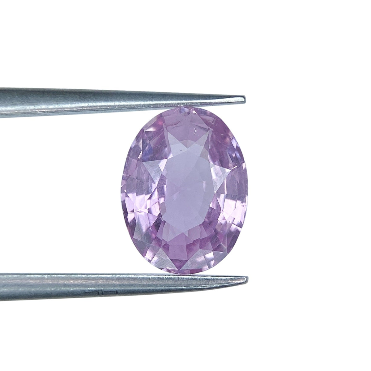 2.06ct oval brilliant cut pink sapphire held in metal tweezers against a white background.