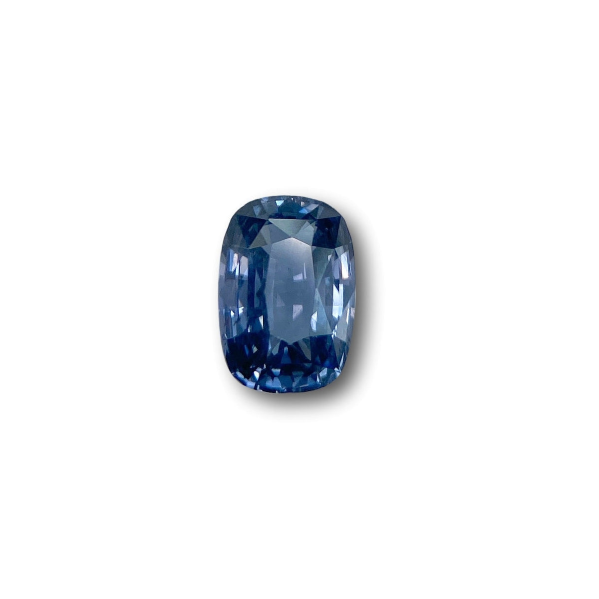 2.39ct brilliant cut cushion-shaped blue spinel gemstone with faceted edges on a white background.