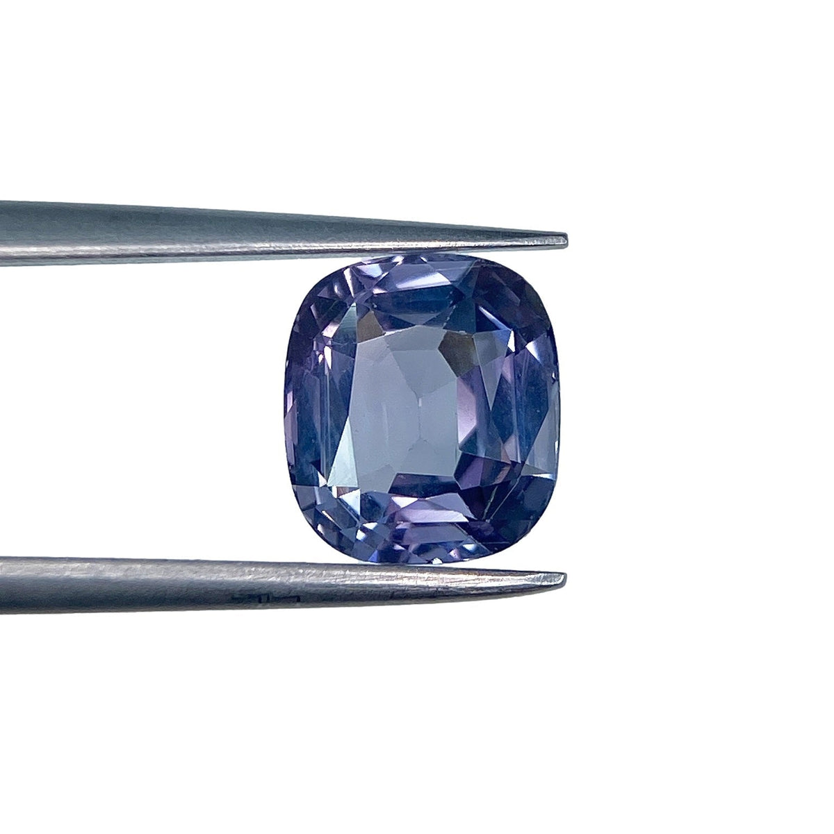 2.58ct brilliant cushion-cut purple spinel gemstone held in metal tweezers against a white background.